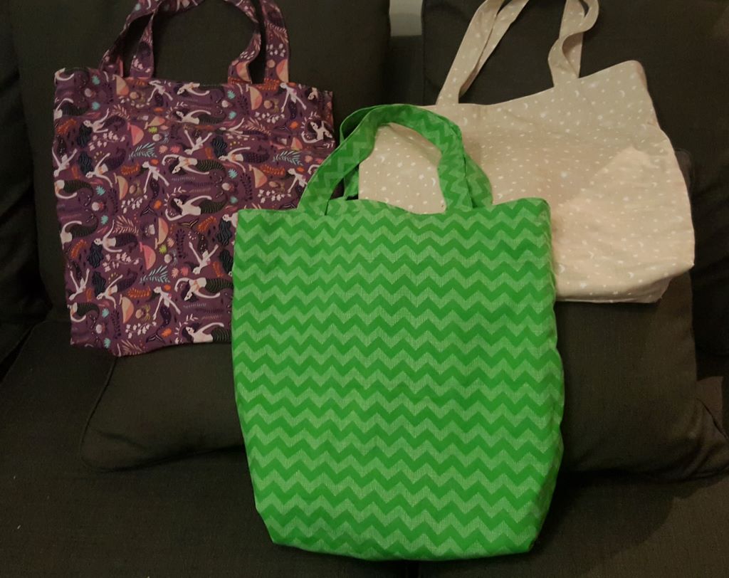 3 tote bags: mermaid, green zig zag and cream colored, white starred
