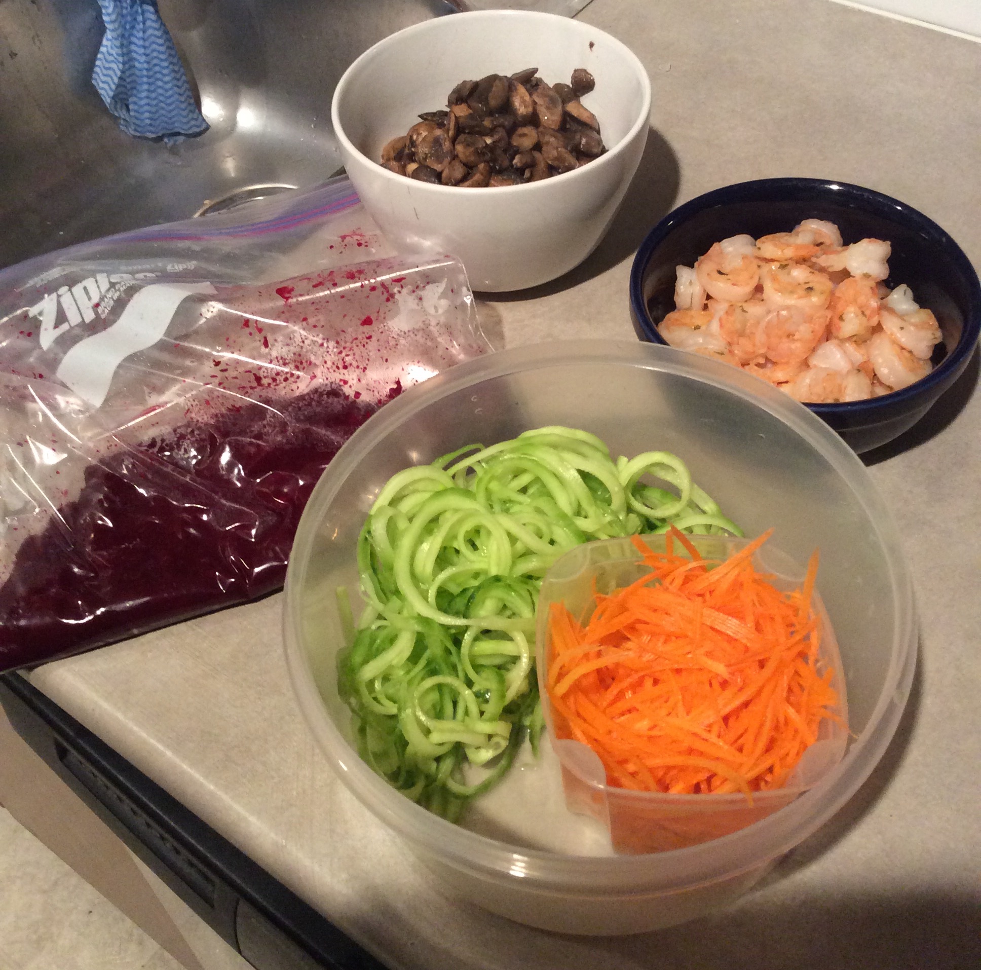 Picture of sauteed mushrooms, garlic shrimp, pureed beets and spiralized cucumbers and julienned carrots