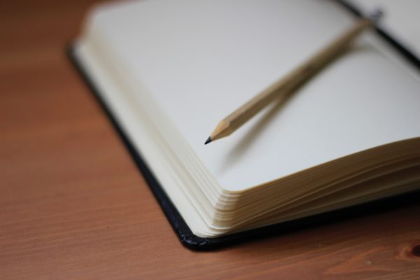 Photo of a blank paged notebook and pencil, by Jan KahÃ¡nek on Unsplash