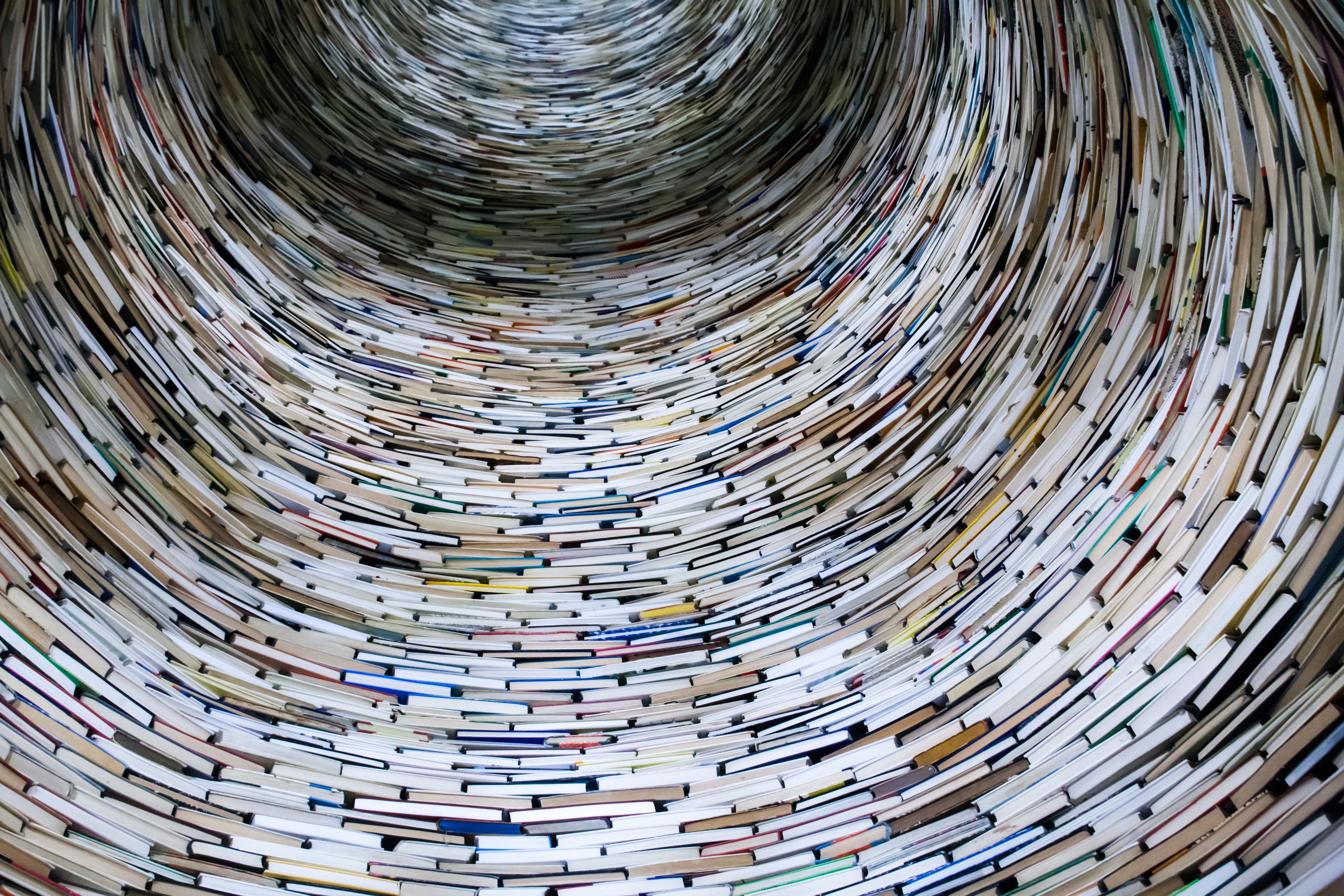 A round circle made up of books, looking like a tunnel. Photo by _HealthyMond . on Unsplash