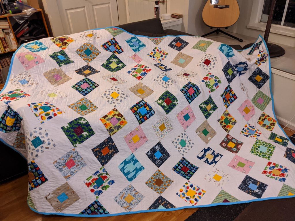 Finished animal themed patchwork quilt laid across the couch