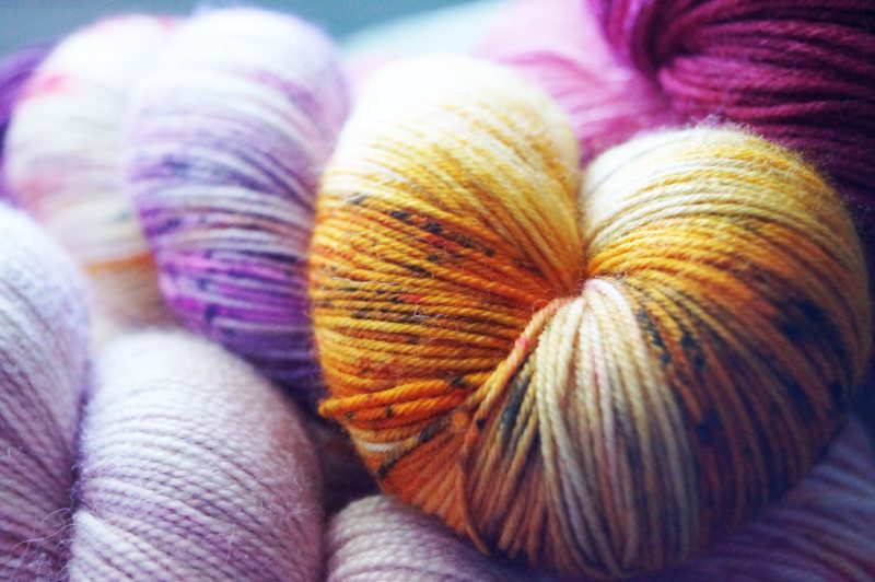 Several colorful skeins of yarn. Photo by Hannah Cole on Unsplash